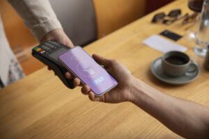 a person holding a phone and a credit card reader